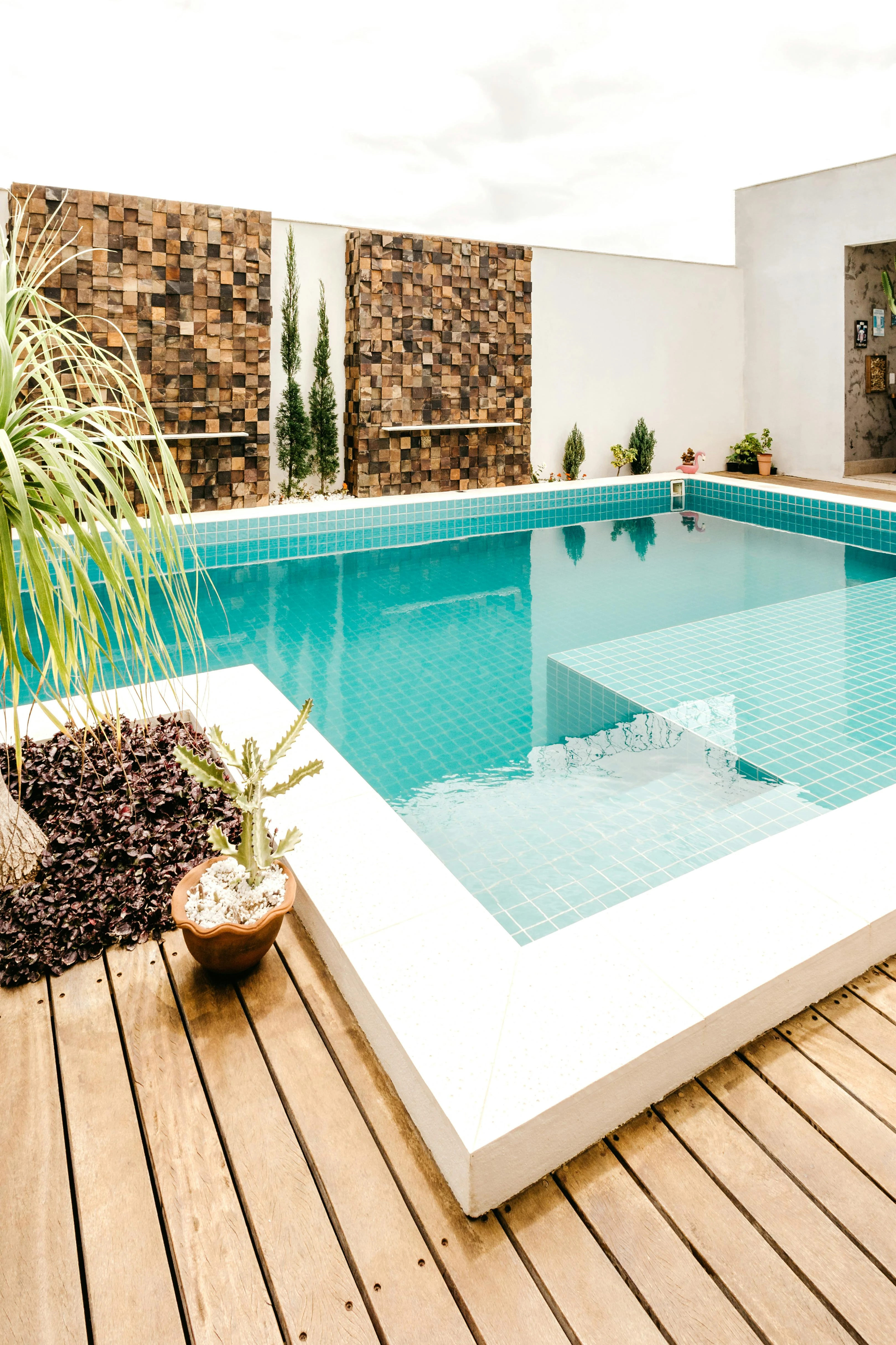 A modern backyard with clean lines, a wooden deck, and minimalist planting.
