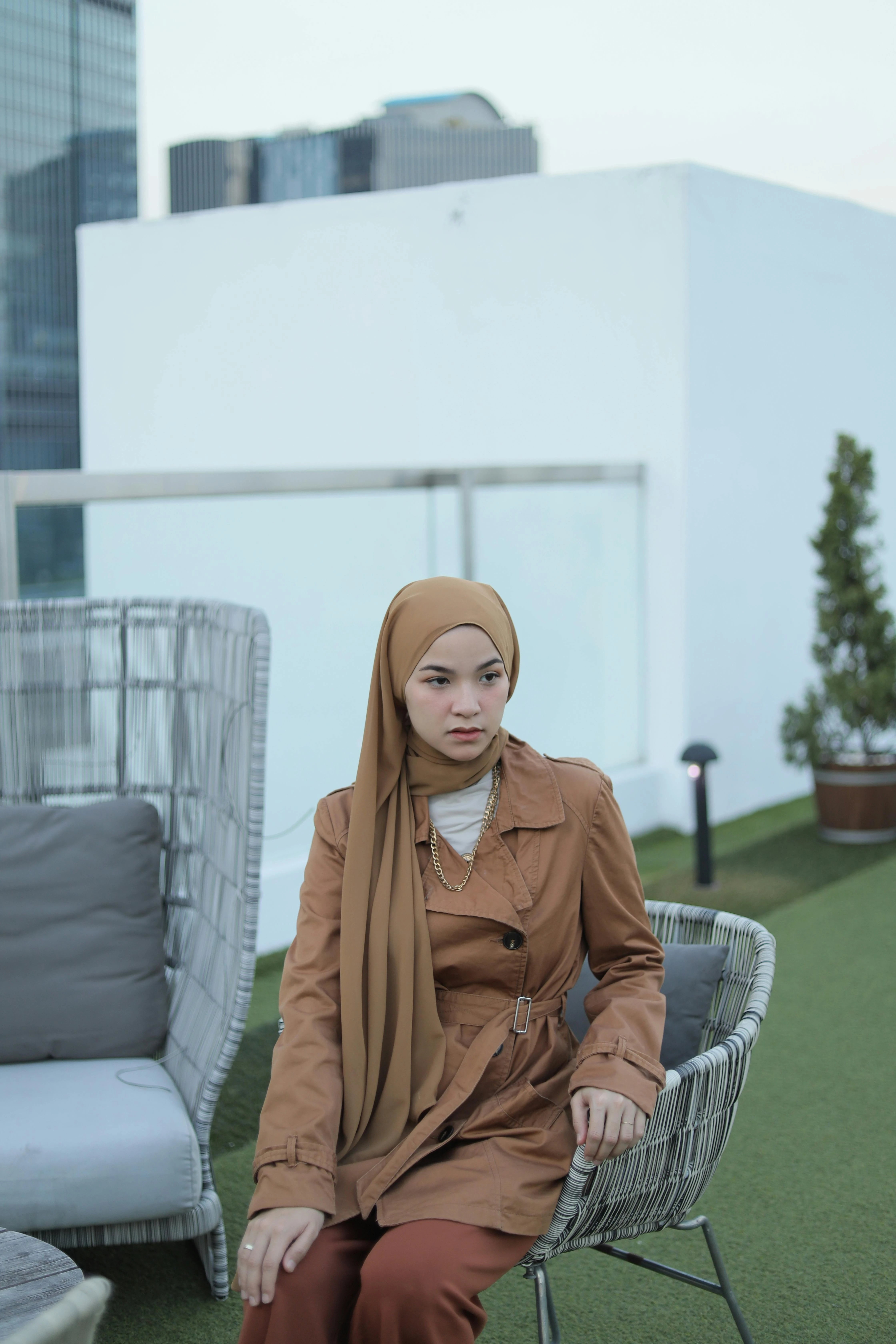 A stylish rooftop garden with container plants, comfortable seating, and city views.